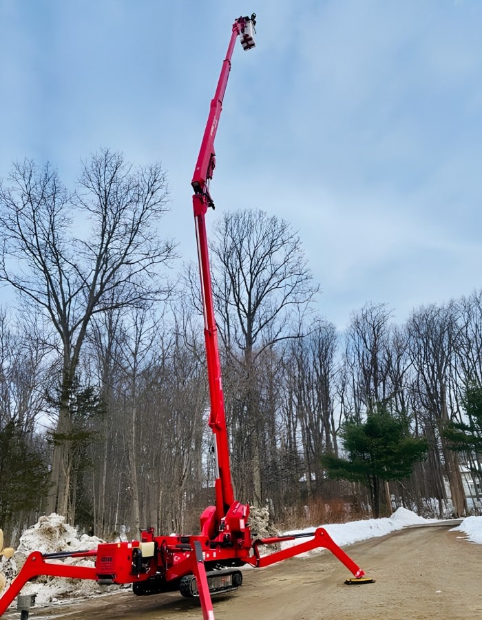 Alpine Tree tracked bucket lift positioned for winter tree removal and pruning operation
